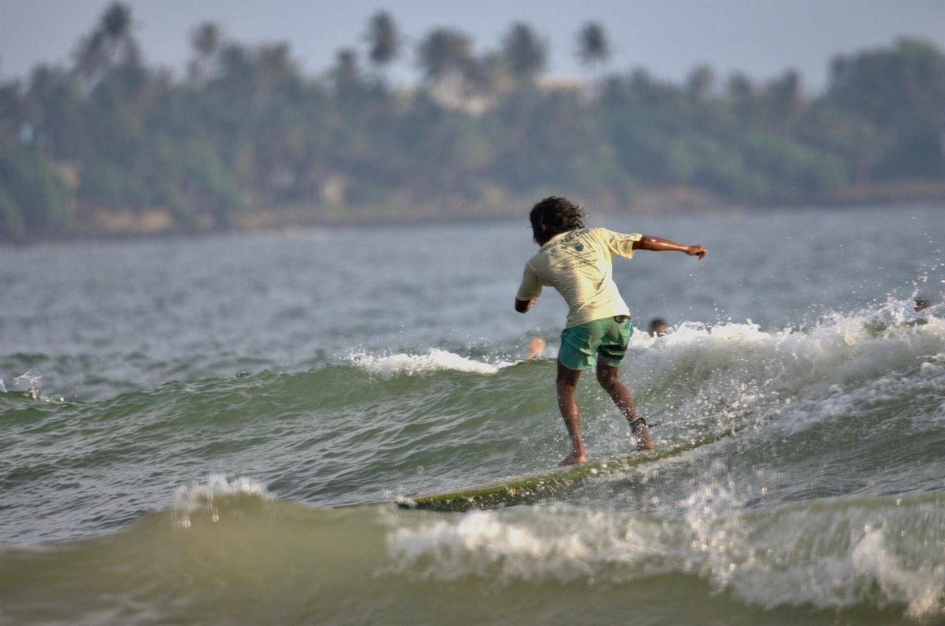 Surfer riding a wave at Weligama Bay